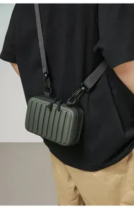 Vista detallada de un bolso de caja rígida verde militar usado como bandolera por un modelo