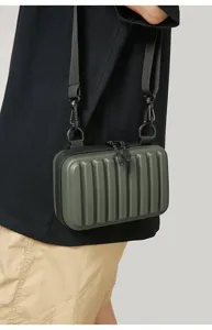 Vista detallada de un mini bolso bandolera rígido verde llevado por un modelo real
