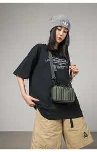 Vista detallada de una modelo con el mini bolso rígido verde oliva en estilo streetwear
