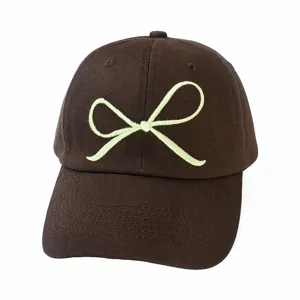 Nahaufnahme der braunen Baumwoll-Baseballcap mit einem süßen bestickten Schleifendesign.