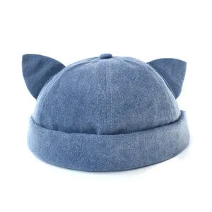 Primo piano del cappellino docker in denim con orecchie di gatto, trama fine e design senza tesa elegante.