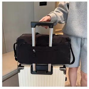 Grande borsone da viaggio nero in tessuto resistente con fascia trolley per trasporto.