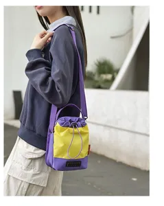 Vista dettagliata di una borsa a secchiello viola e gialla sulla spalla di una modella.
