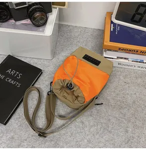 Vista dettagliata della borsa a tracolla arancione e kaki con coulisse in tessuto nylon