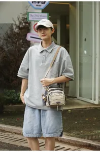 Ein Mann trägt einen stylischen Mini-Wanderrucksack im Freien in einer Stadtumgebung.