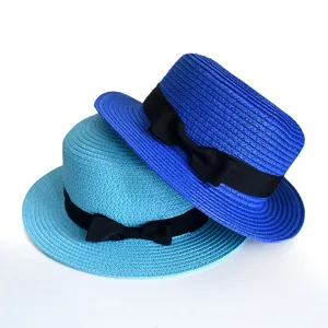 Detailed view of the fashionable flat top straw hats featuring classic black bow ribbons.