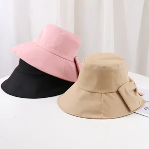 Vue détaillée de chapeaux de pêcheur élégants avec nœud papillon en rose, noir et kaki