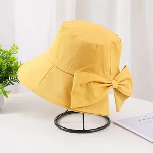 Détail du chapeau bob en coton jaune avec grand nœud et fente à l'arrière pour l'été