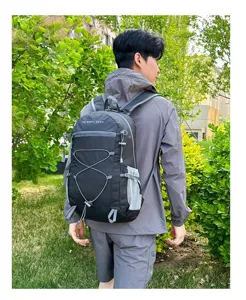 Detaillierte Outdoor-Aufnahme eines leichten, dunkelgrauen Rucksacks mit Gummizug und Netztaschen.
