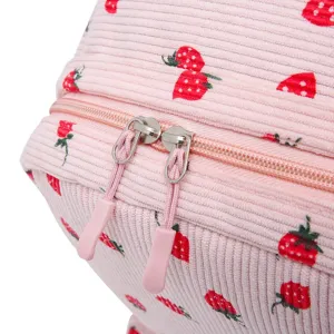 Close-up detail of strawberry pattern and dual zipper on pink corduroy backpack