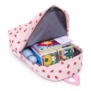 Internal capacity view of pink strawberry print backpack showing books and accessories