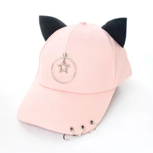 Détail d'une casquette rose avec oreilles de chat noires et étoiles en anneau métal