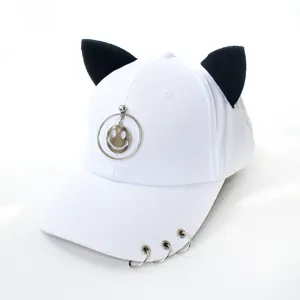 Détail d'une casquette de baseball en toile blanche avec oreilles de chat et anneaux.