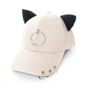 Vue détaillée d'une casquette beige avec des oreilles de chat noires et des anneaux étoiles