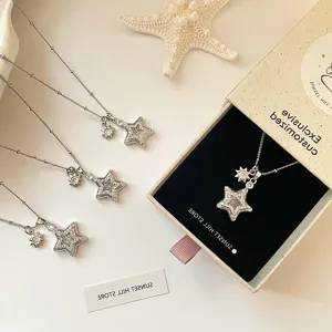 Close-up of star zircon pendant necklace in elegant gift box with starfish prop