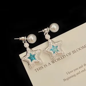 Silver star earrings with micro-paved zircons and blue center stone and pearl accent