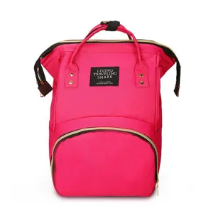 Gedetailleerd zicht op de roze nylon stoffen rugzak met een zwart logo-embleem.