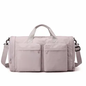 Grand sac de voyage pliable avec poches avant et bandoulière réglable en détail.