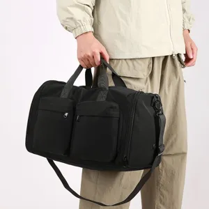 Grand sac de voyage noir avec poches avant et bandoulière réglable pour le sport.