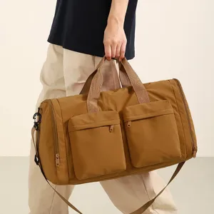 Vue détaillée du grand sac de voyage montrant les poches avant et la bandoulière.