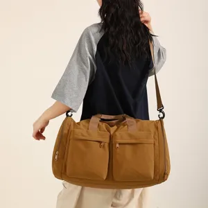 Grand sac de sport étanche marron en nylon avec deux poches avant et une sangle d'épaule.