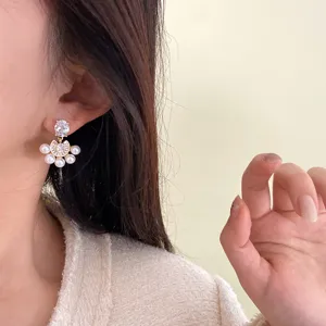 Vista detallada de elegantes pendientes de abanico con perlas y circonitas en la oreja de una modelo