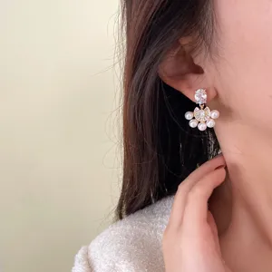 Primer plano de elegantes pendientes de perlas y circonitas con forma de abanico