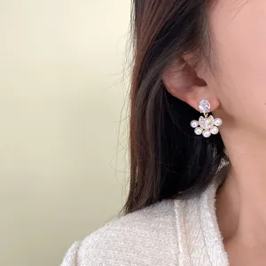 Primer plano de elegantes pendientes de abanico con perlas y circonitas estilo francés