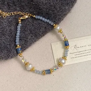 Primer plano detallado de una pulsera de piedras naturales azules y perlas de agua dulce