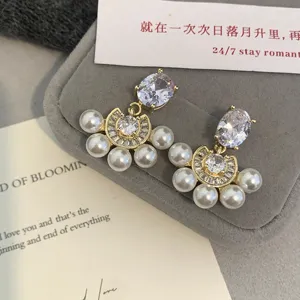 Detalle de los elegantes pendientes de perlas en forma de abanico estilo francés