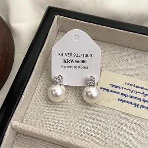 Nahaufnahme von französischen Perlenohrsteckern mit Zirkon-Inlay in der Schmuckbox
