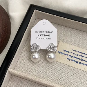 Detail von eleganten Perlenohrringen mit funkelndem Zirkonia-Knoten auf S925 Silber