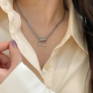 Detailansicht einer dreilagigen Sternkette mit Zirkonia und türkisfarbenen Anhängern.