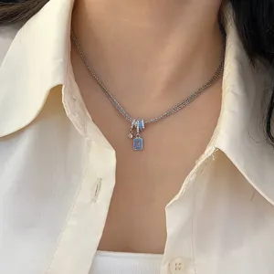 Nahaufnahme einer dreifachen Halskette mit blauem Zirkon und Emaille-Anhängern