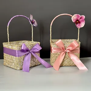 Handmade seagrass woven basket with elegant satin ribbon bow and orchid decor, perfect for gifts.