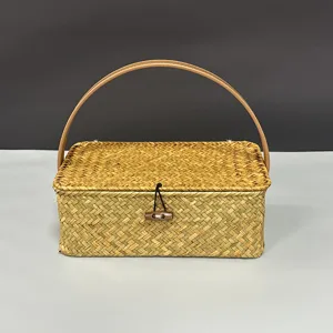 Handmade woven rattan storage basket with lid, arched handle and wooden toggle for gifts.