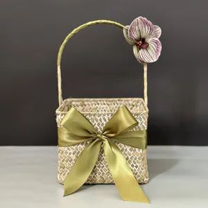 Handmade seagrass woven gift basket with green satin bow and flower for wedding and parties.
