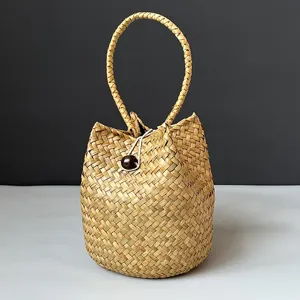 Close-up detail of the natural weave and bead closure on a handmade seagrass bag
