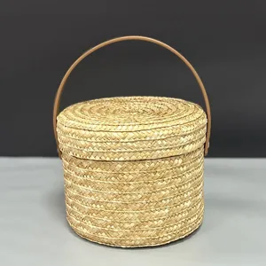 Detalle de cesta redonda de paja hecha a mano con asa de cuero para regalos