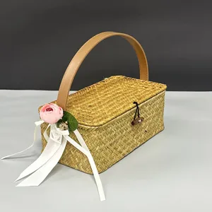 Close-up detail of the woven straw basket featuring a wooden toggle closure and floral ribbon.
