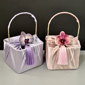 Elegant satin gift box with handle, pearl string, and flower detail for weddings and parties.