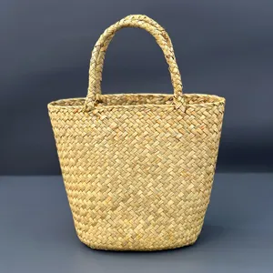 Detailed close-up view of the woven straw tote bag showing fine texture and sturdy double handles.