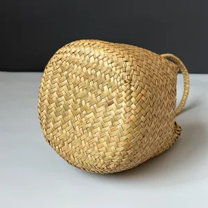 Bottom detail of a handmade seagrass woven basket bag showing fine natural texture