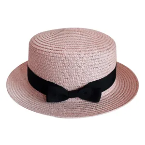 Pink straw boater hat detail, featuring classic black ribbon bow and breathable woven texture.