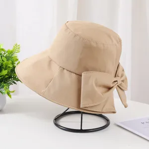 Détail d'un chapeau bob kaki avec un grand nœud et une fente pour protection solaire.