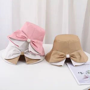 Détail de chapeaux bobs élégants pour femmes avec nœud en rose et kaki