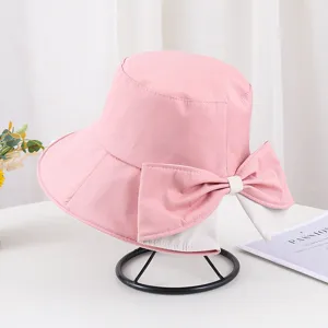 Détail montrant l'élégant nœud rose et le bord fendu du chapeau de soleil pour femme
