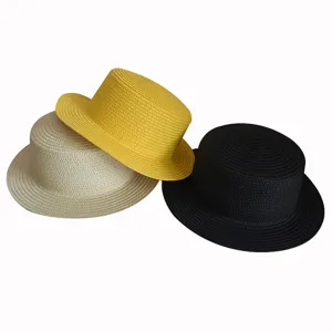 Detail view of stylish flat top straw hats in beige, yellow and black, woven design.
