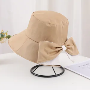 Gros plan d'un chapeau bob kaki avec un grand nœud et un design élégant à bord fendu.