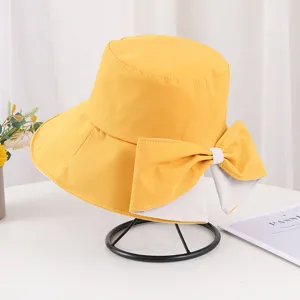Vue détaillée d'un élégant chapeau bob jaune avec un grand nœud décoratif pour femme.